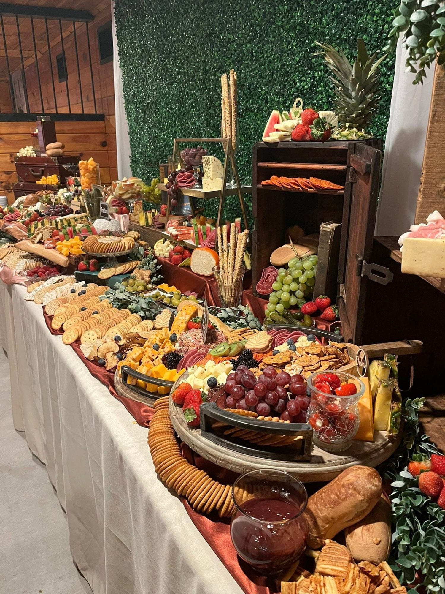 A Just Desserts grazing table flowing with cheeses, seasonal fruit, and crackers