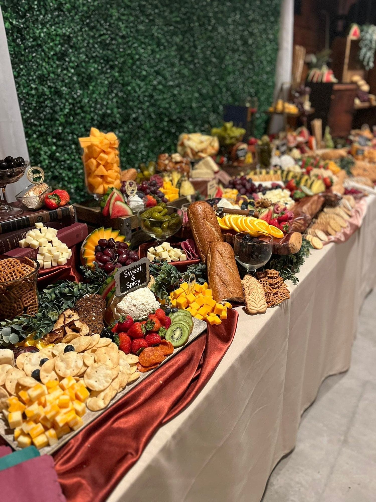 A thirty-foot charcuterie display styled in front of a green wall